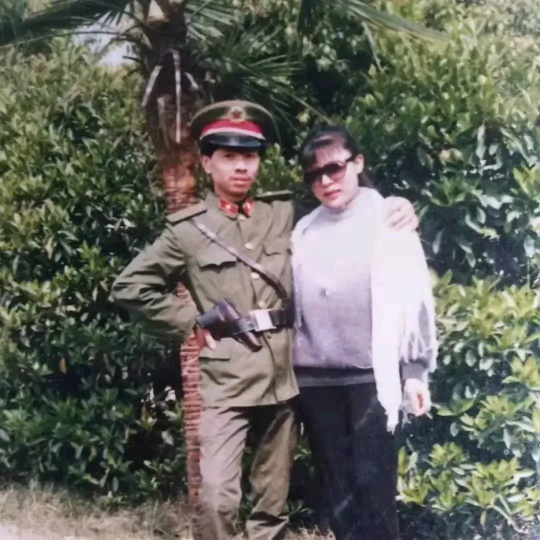 这张照片拍摄于1980年代，一名身穿军装的男子和他女